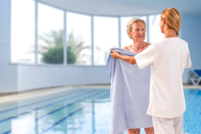 woman giving towel to senior woman