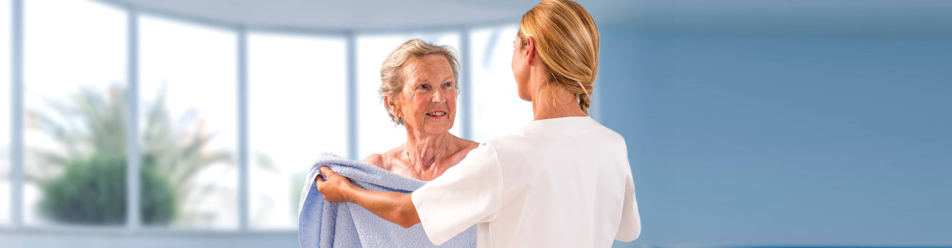 woman giving towel to senior woman